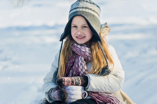 Little girl holds hot cup of tea outdoor. Winter time