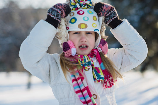 little girl in warm clothing outdoor in winter park