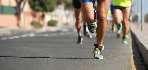 Marathon runners running on city road,detail on legs