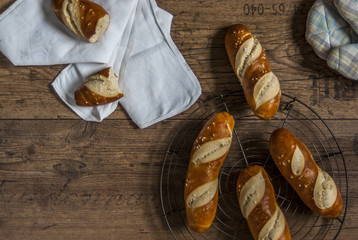 Laugenstangen gesalzen nach dem Backen auf Backrost Nudelholz Schüssel Küchentuch Backpapier Lye pretzels after baking on baking grid rolling pin bowl kitchen towel baking paper