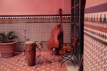 Zelfklevend Fotobehang Muziekinstrumenten op de achtergrond van een decoratieve muur, straten van Havana, Cuba © Made