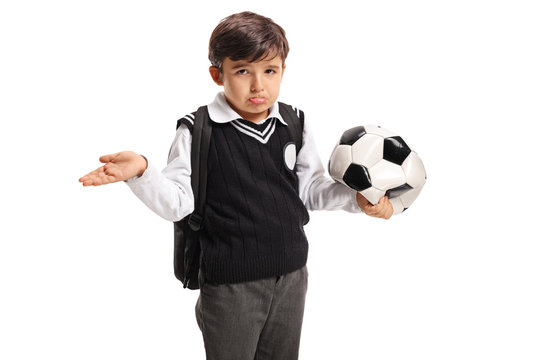 Disappointed little schoolboy holding a deflated football