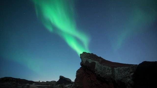 Aurora borealis swirling over moonlit jagged volcanic terrain Iceland pro res 444.mov