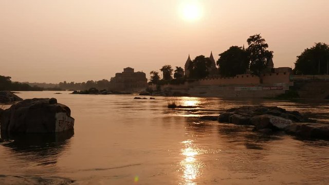 Cenotaphs at Orchha, Madhya Pradesh, famous travel destination in India. Holy Betwa river flowing at sunset.