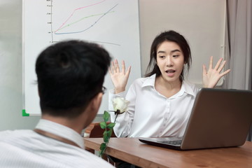 Surprised young Asian woman excited to get a white rose in office on valentine's day. Love and romance in workplace concept.