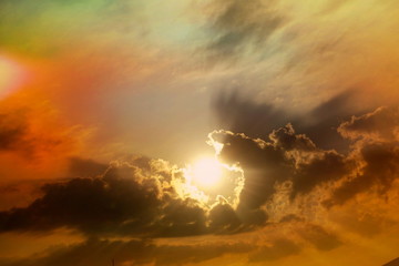 Sonnenstrahlen leuchten durch düstere Wolken hervor und färben den Himmel in atemberaubenden...