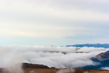 A dreamy mountain scene with clouds cover on a mountain hill