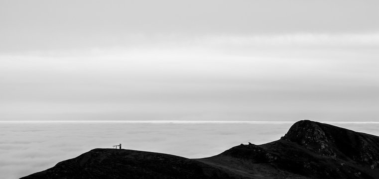 Fototapeta A tranquil mountain scene with clouds cover on a hill. Black and white