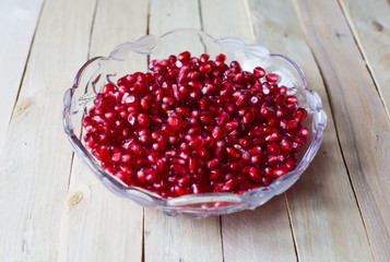 Pomegranate seeds on wooden background