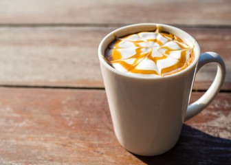 A cup of hot coffee on wooden table in the morning.