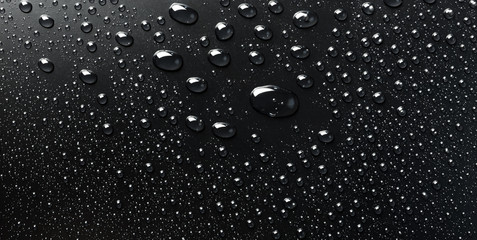Water drops on a black surface, abstract background