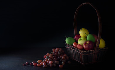 Fresh and withered fruits with Light in dark background / Still Life image and space for message..