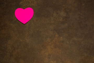 Hearts of various colors on brown background for St. Valentine's Day