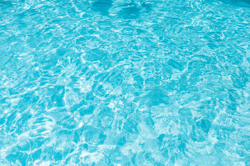 Blue and bright water surface and ripple wave with sun reflection in swimming pool