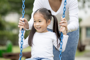 Mom is playing with her little daughter on a terrace with swings. Family lifestyle Concept....
