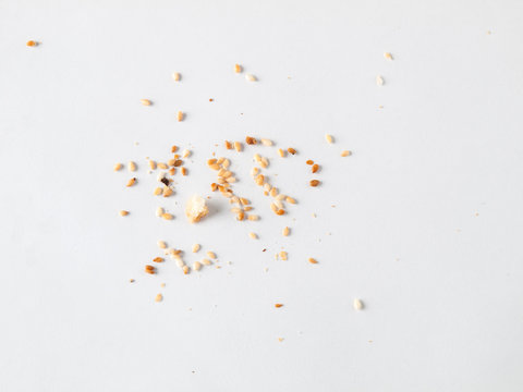 Scattered sesame seeds and crumbs isolated on white background