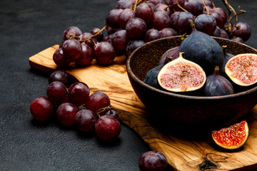 Ripe Grapes and Figs on dark concrete background