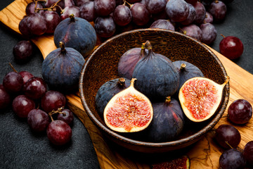 Ripe Grapes and Figs on dark concrete background