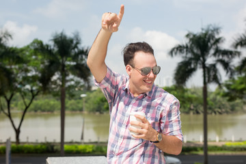 Happy young male tourist with coffee catching taxi
