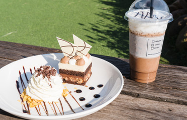 Brownie cake and whipped cream and iced coffee with air in the afternoon  a snack play which help refreshing up and ready to go back to work.