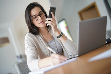 Businesswoman working from home talking on phone