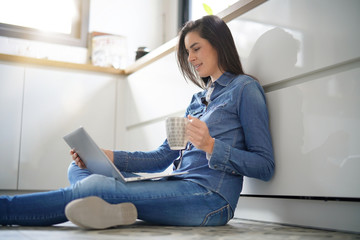 Woman sitting on floor connected with laptop