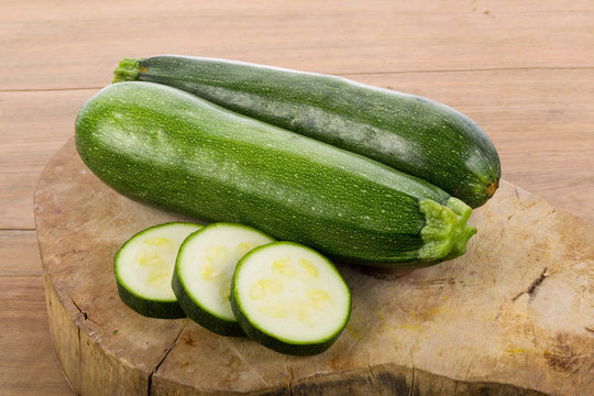 green zucchini vegetables on wooden background