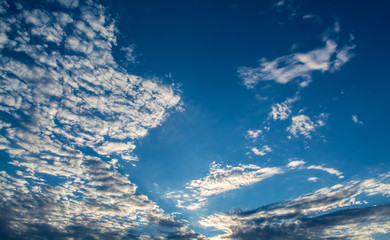 Naklejka na ściany i meble White curly clouds in a blue sky. Sky background