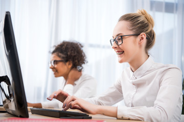 young attractive teenager girls studying on computers