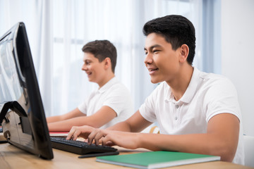 Obraz premium young happy teenager boys studying on computers