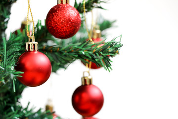 Obraz na płótnie Canvas Red decoration ball on green christmas tree with white background