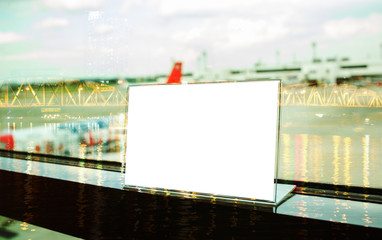 Mock up white Label on table for blank menu frame in restaurant in ariport, Stand for acrylic tent card Used for Menu Bar, blur of light background insert for text of customer.