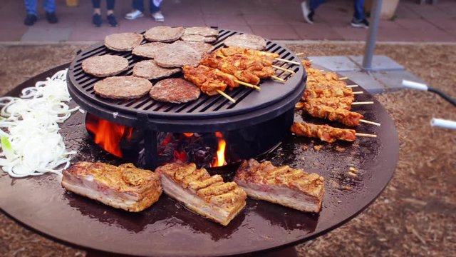 garden barbecue adding Livar pork roast to the hot plate