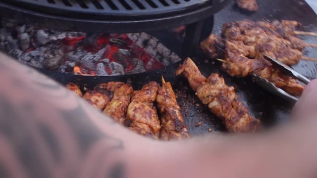 garden barbecue turning chicken kebabs