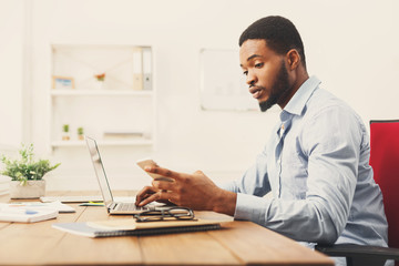 Fototapeta premium Young black businessman using mobile phone