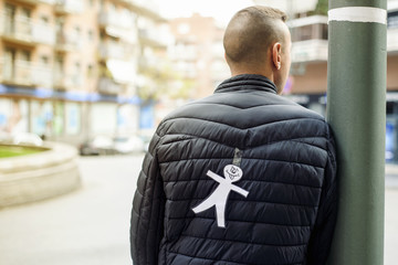 young man with a paper man attached to his back
