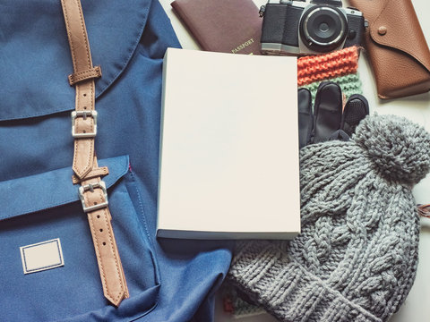 long holiday travel flat lay concept from winter cloth item and blue backpack with passport , retro camera , sunglasses and book put on isolated white background