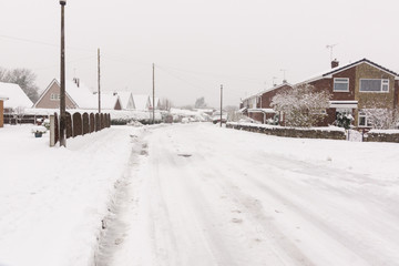 Fototapeta premium Heavy snowfall on a housing estate in the United Kingdom with roads blocked by snow and ice