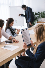 Fototapeta premium overworked businesswoman in conference hall holding contract upside down at office