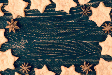 The horizontal Christmas background of blue vintage table, and cookies stars and star anise. Background with copy space toned teal orange