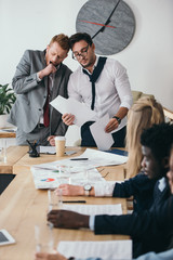 group of managers having conversation in conference hall at office
