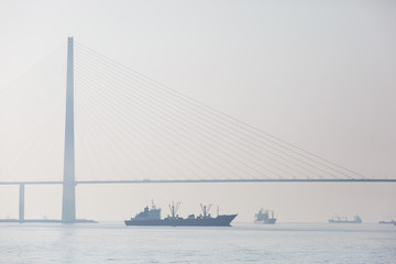 Amazing zooming out aerial view of the Russky Bridge, the world's longest cable-stayed bridge, and the Russky (Russian) Island in Peter the Great Gulf in the Sea of Japan. Sunrise. Vladivostok, Russia