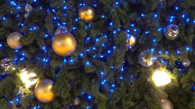 Golden Christmas ball hanging on Christmas tree with blue bokeh in night time