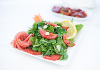 fresh vegetable green vegetarian arugula salad with tomatoes and garlics