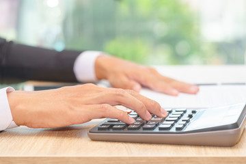 Hands of businessman pushing calculator for calculating a receipt - financial concept.