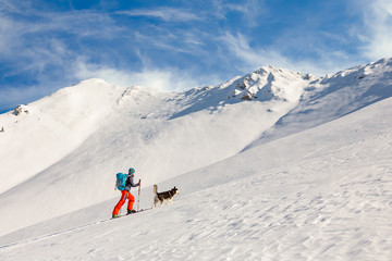 Young man backcountry skiing, going uphill on the mountain, with