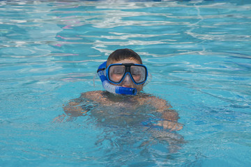 Naklejka premium The little boy in the water with diving equipment