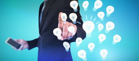 Composite image of mid section of businessman holding smartphone