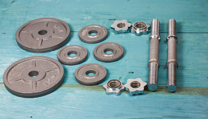 Top view of accessories for fitness in grey tone. Dumbbells, weight plates.