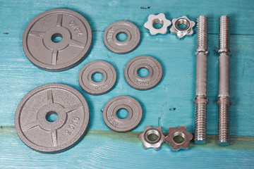 Top view of accessories for fitness in grey tone. Dumbbells, weight plates.